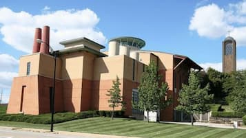 A building with a modern architectural style, featuring a prominent cylindrical tower and a flat roof.
