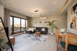 A modern living room with a sofa, coffee table, and dining area. - Delightful stay at Degla by Spacey #39 (Cairo)