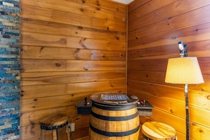 Ein Holzsaunaraum mit einer hölzernen Sitzbank, einer Saunaheizung und einer Lampe.
