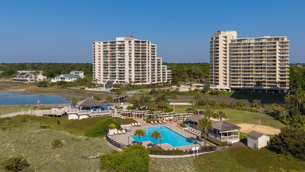 Ein Resort mit Schwimmbad, mehreren Hochhäusern und einer Strandanlage.