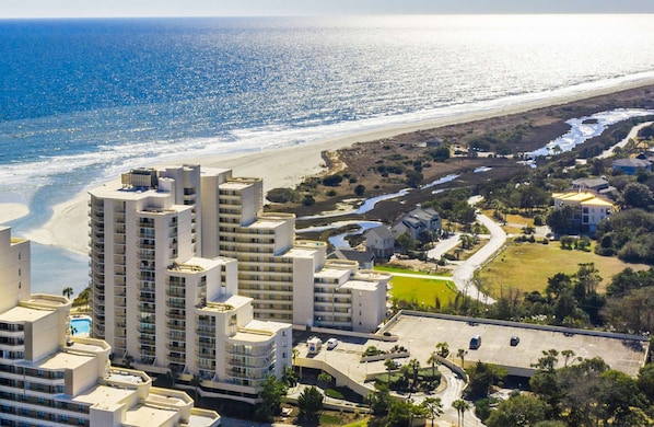 A coastal hotel with multiple high-rise buildings, a beach, and a parking area. - Spacious 3BR Condo + Beach Access, Kitchen & Pools (Myrtle Beach)