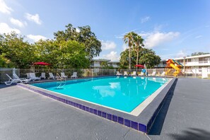 Ein rechteckiger Pool mit einer gefliesten Kante, umgeben von einem weißen Zaun.