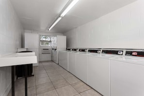 Una sala amb bugaderia, amb una filera de rentadores, un rentapeus i una finestra.