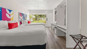 Une chambre d’hôtel moderne avec un grand lit, un bureau et une télévision.