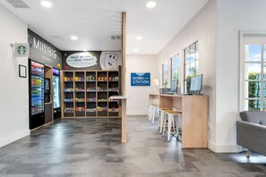 A modern workspace with a vending machine, snack shelves, and a work station area. - Close to Disney World Resort + Free Breakfast (Kissimmee)