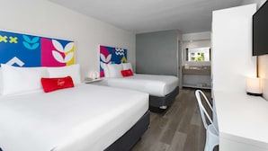 Une chambre d’hôtel avec deux lits, un bureau et une salle de bain.