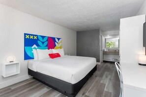 Ein modernes Hotelzimmer mit Bett, Badezimmer und Fernseher.