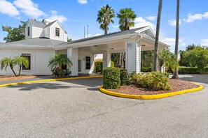 A two-story building with a covered entrance and a gravel driveway. - Mins to Disney World Resort + Free Shuttle & Pool (Kissimmee)