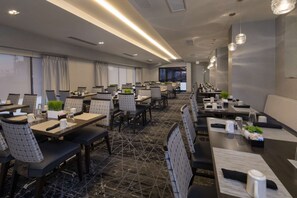 A conference room with multiple tables and chairs, equipped with laptops, arranged for a meeting. - Stay in College Park | Group‑Friendly. Pool. Bar. (College Park)