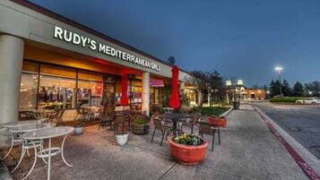 A restaurant named 'RUDY'S MEDITERRANEAN GRILL' with outdoor seating and a paved walkway.