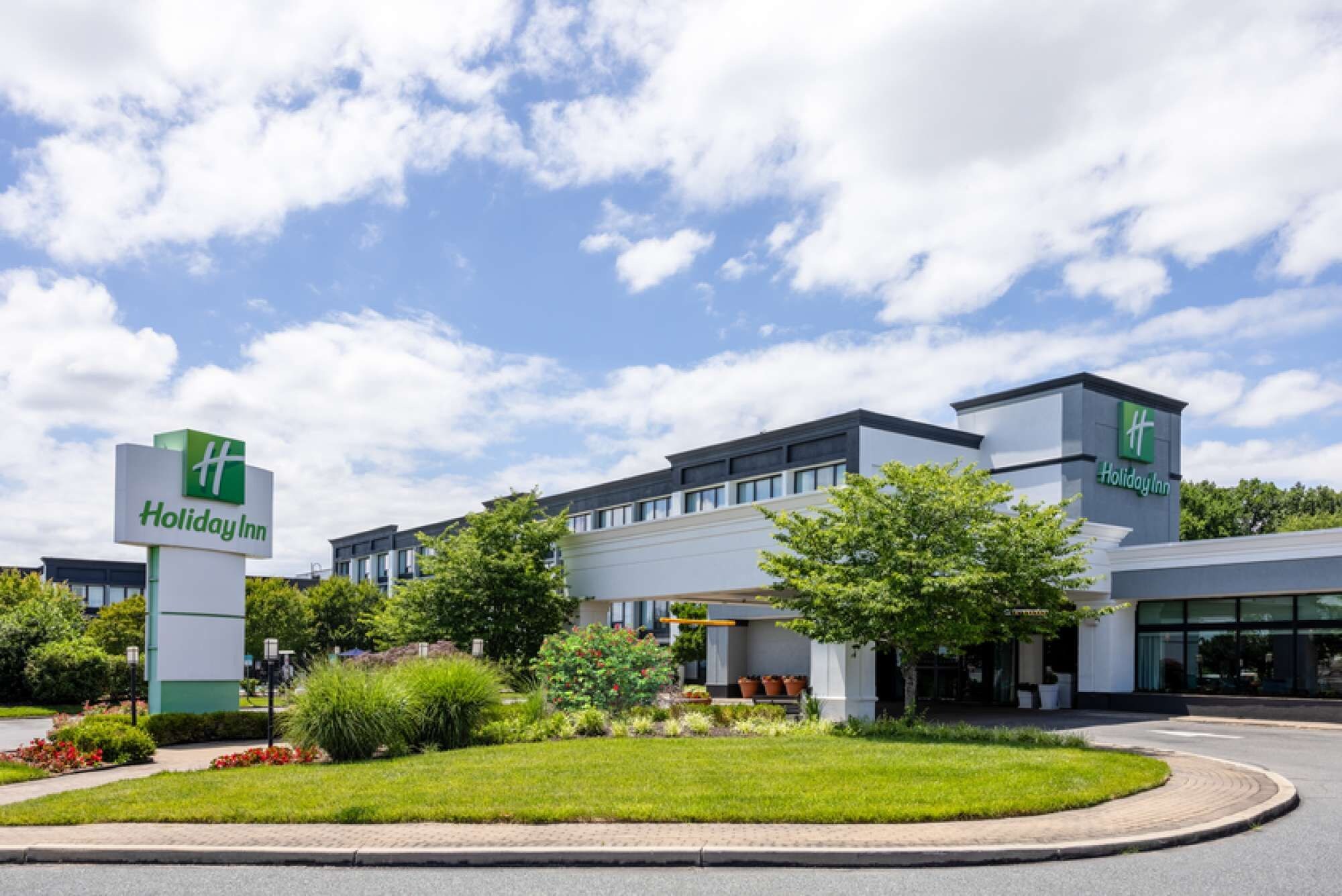 A Holiday Inn hotel with a modern design, featuring a large building with a flat roof and multiple windows.