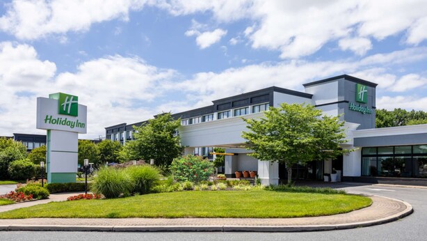 Et Holiday Inn hotel med et moderne design, med en stor bygning med fladt tag og mange vinduer.