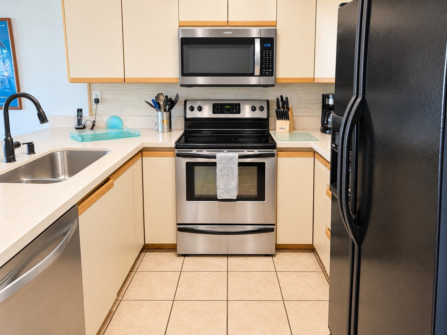 Een moderne keuken met een RVS magnetron, oven en koelkast, met een overzichtelijke en praktische indeling.