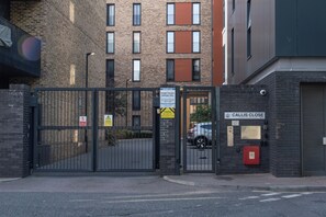 A gated entrance to a building with a sign indicating 'CALLIS CLOSE' and a 'PERMIT HOLDER PARKING ONLY' sign. - Spacious Woolwich Apartment With sea View (London)