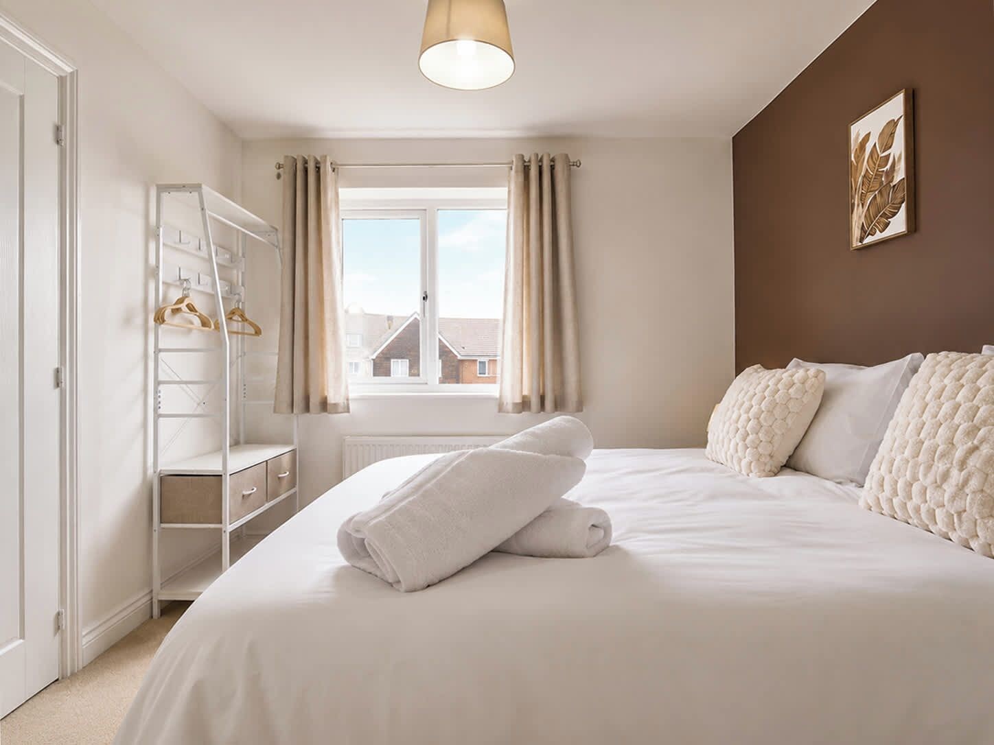 Een slaapkamer met een bed, een kledingkast en een raam met gordijnen.