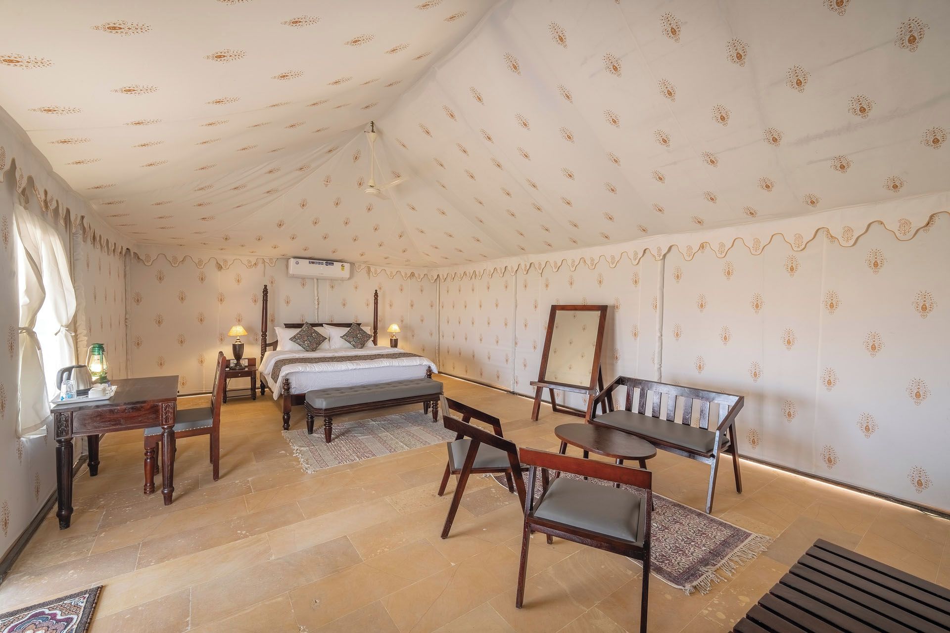 Un dormitorio amplio con una cama grande, un escritorio, una silla y una mesita.