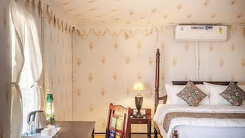 Una habitación de hotel con una cama, una mesa con una silla, una lámpara y un radiador.