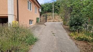 A narrow paved path leading to a building with a gated entrance.