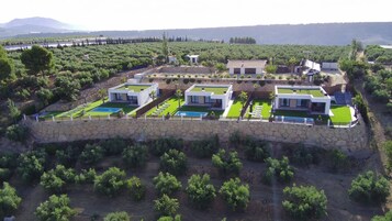 Un barrio residencial con casas modernas, una piscina y un muro de contención de piedra.