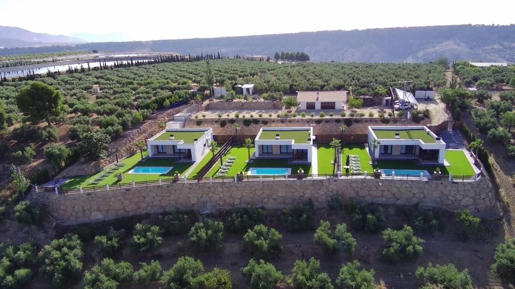 Un moderno resort con varias edificaciones, una piscina y un muro de contención de piedra.