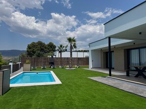 A modern outdoor pool area with a clear view of the mountains in the background.
