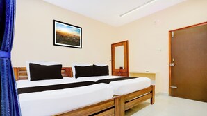Ein Hotelzimmer mit einem Bett, einem Nachttisch, einem Spiegel und einer Tür.