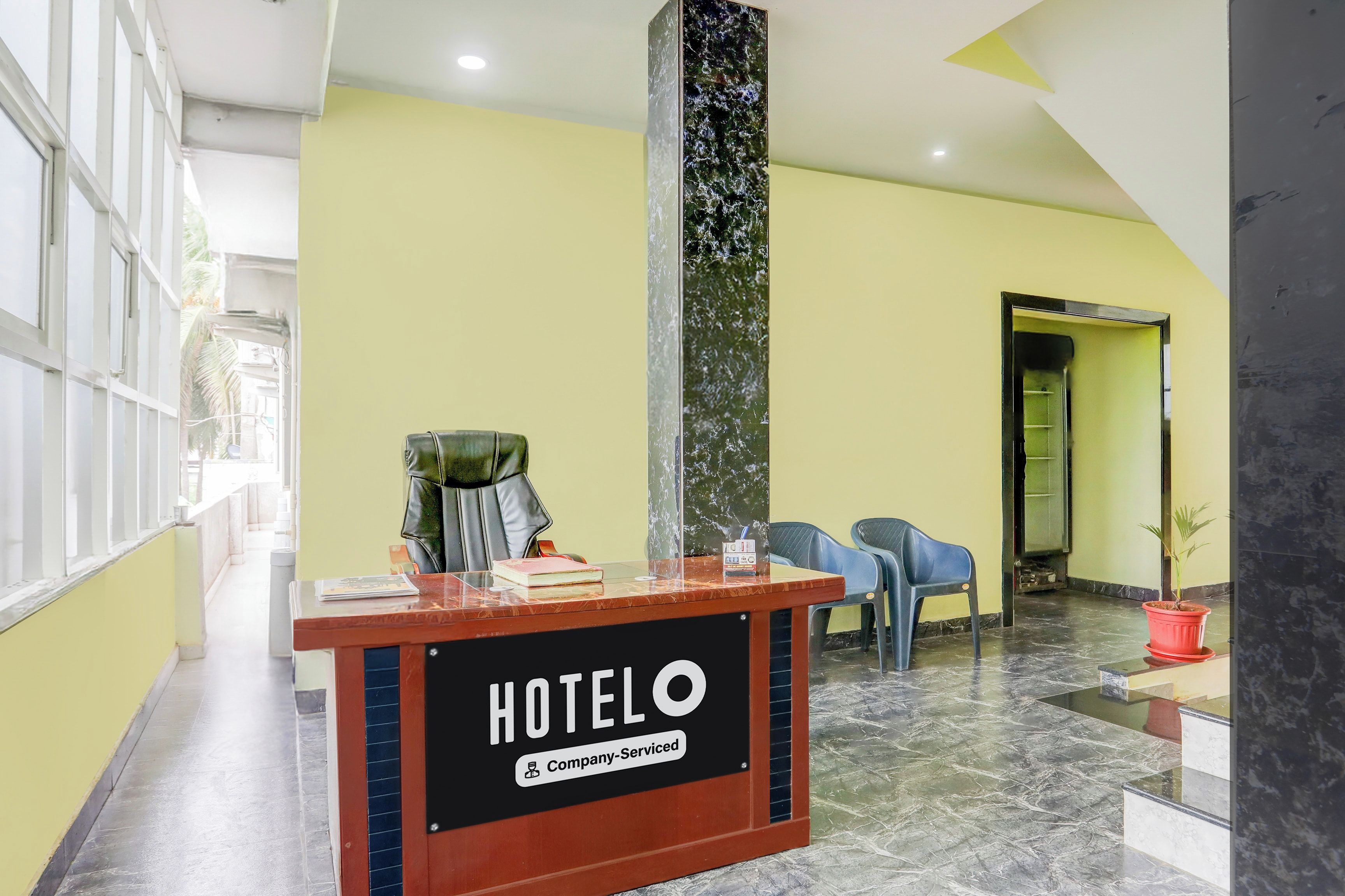 A hotel reception desk with a sign reading 'HOTELO Company-Serviced'.