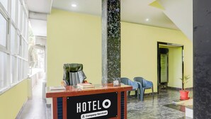 Ein Hotelrezeptionstresen mit einem Schild, auf dem 'HOTELO Company-Serviced' steht.
