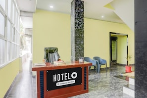 Taulell de recepció d'hotel amb un cartell que diu 'HOTELO Company-Serviced'.