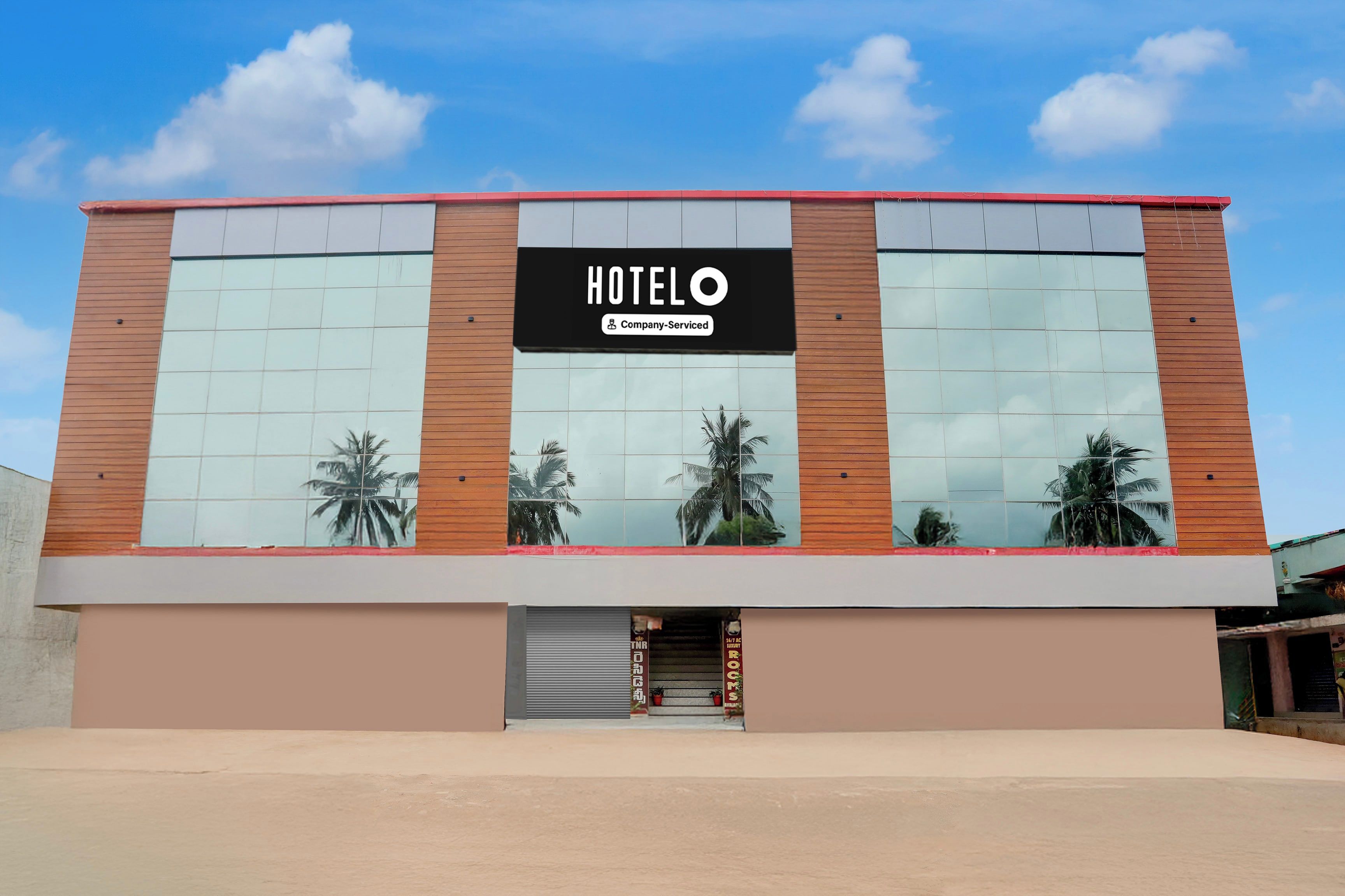 A modern hotel building with a large sign reading 'HOTELO' and a company-serviced label.