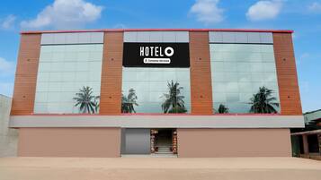 A modern hotel building with a large sign reading 'HOTELO' and a company-serviced label.