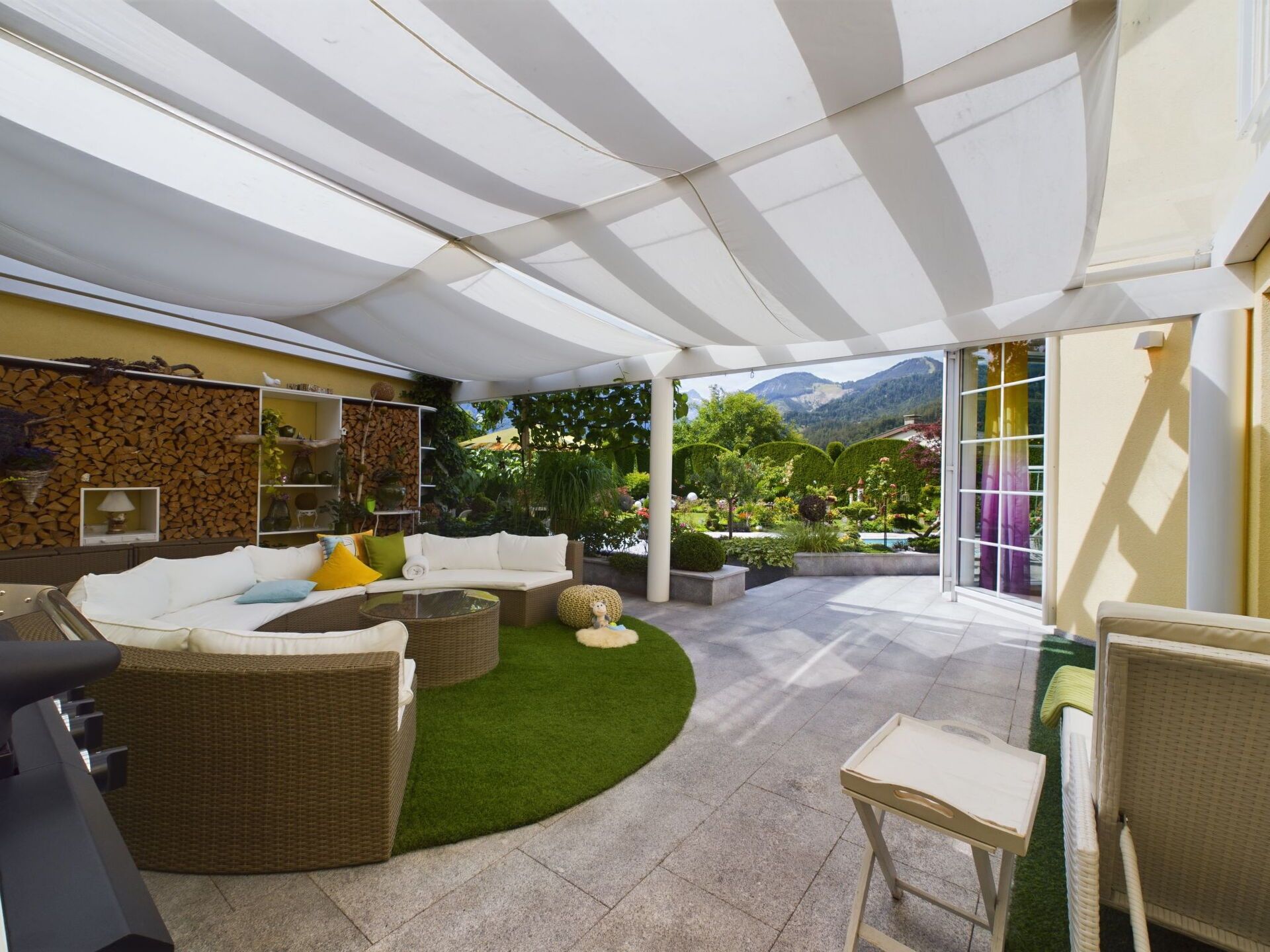 A covered outdoor seating area with a sofa, chairs, and a small table.
