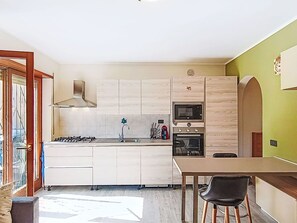 Eine moderne Küche mit Kochinsel, eingebauter Mikrowelle, Backofen und Gaskochfeld.