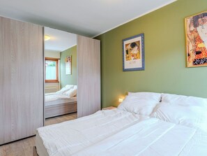Ein Schlafzimmer mit einem Bett, einem Spiegel und Bildern an der Wand.