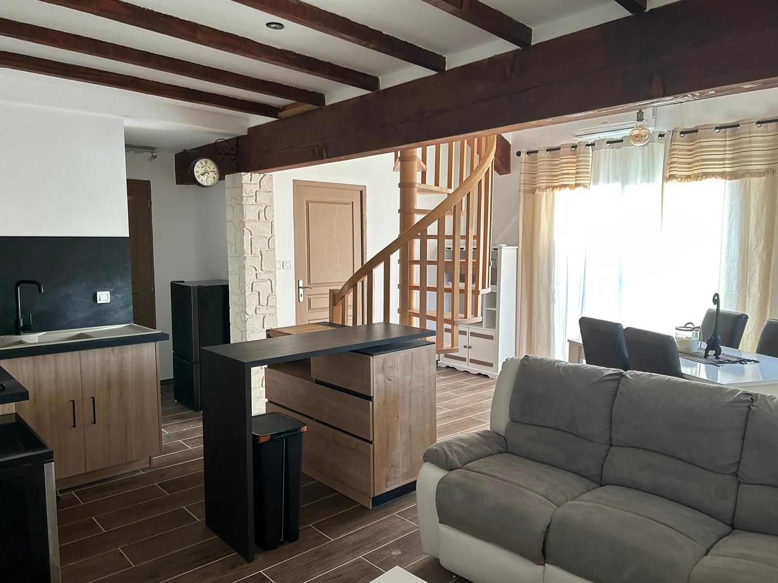 Une cuisine moderne avec des meubles en bois et un plan de travail noir intégré.