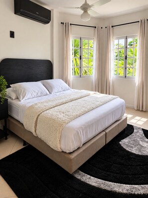 A bedroom with a bed, a ceiling fan, and a window with curtains. - A different Rio experience | Exclusive house with 4 suites near Barra. (Rio de Janeiro)