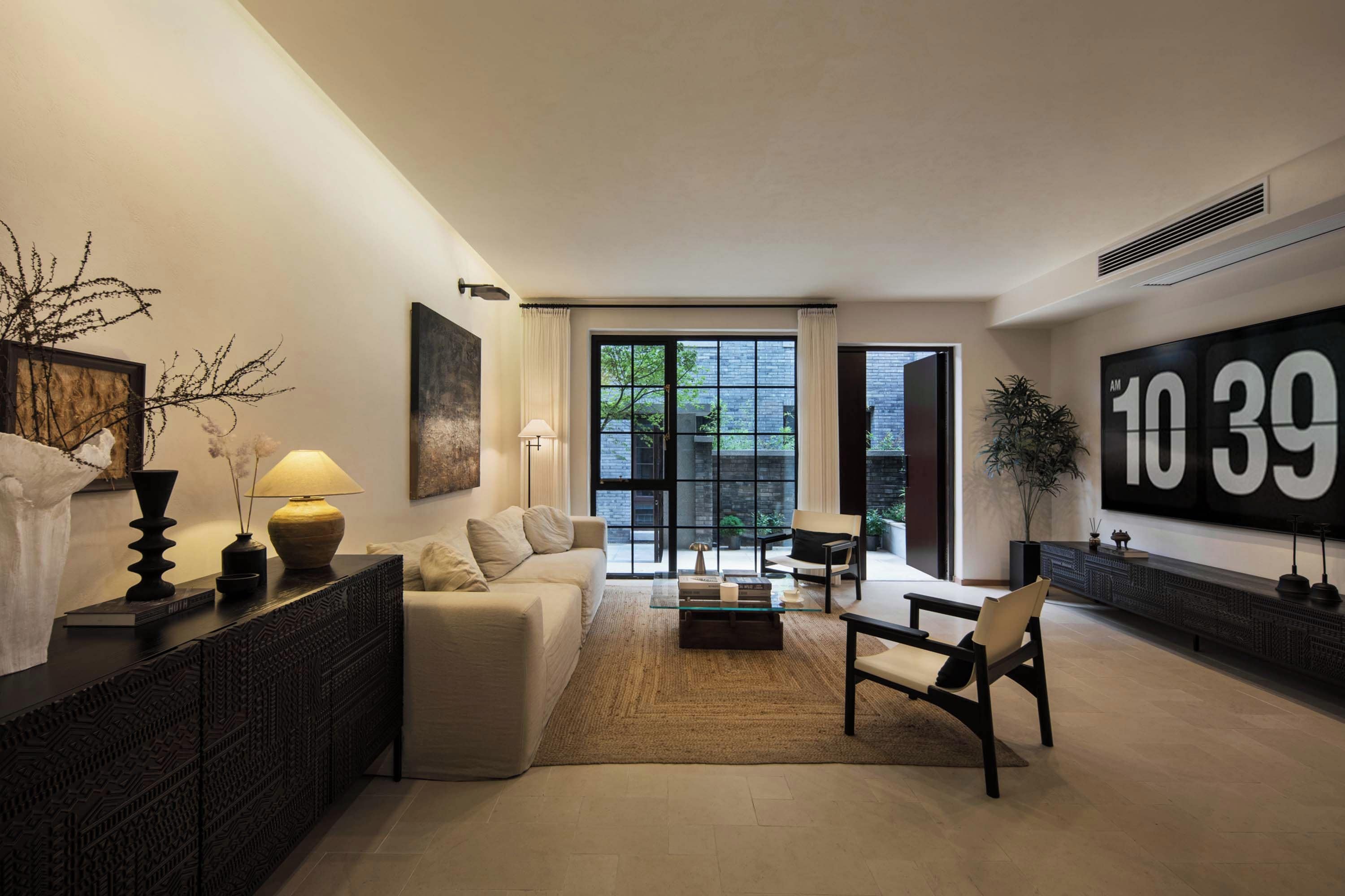 A modern living room with a sofa, coffee table, and a large window.