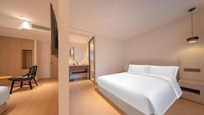 A modern hotel room with a large bed, a desk, a chair, and a television. - Daily Fortune  Tianshun River View Villa (Chongqing)