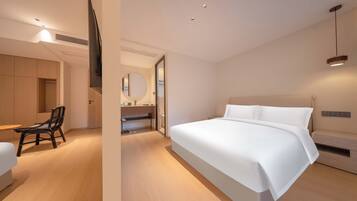 Una habitación de hotel moderna con una cama grande, un escritorio, una silla y un televisor.