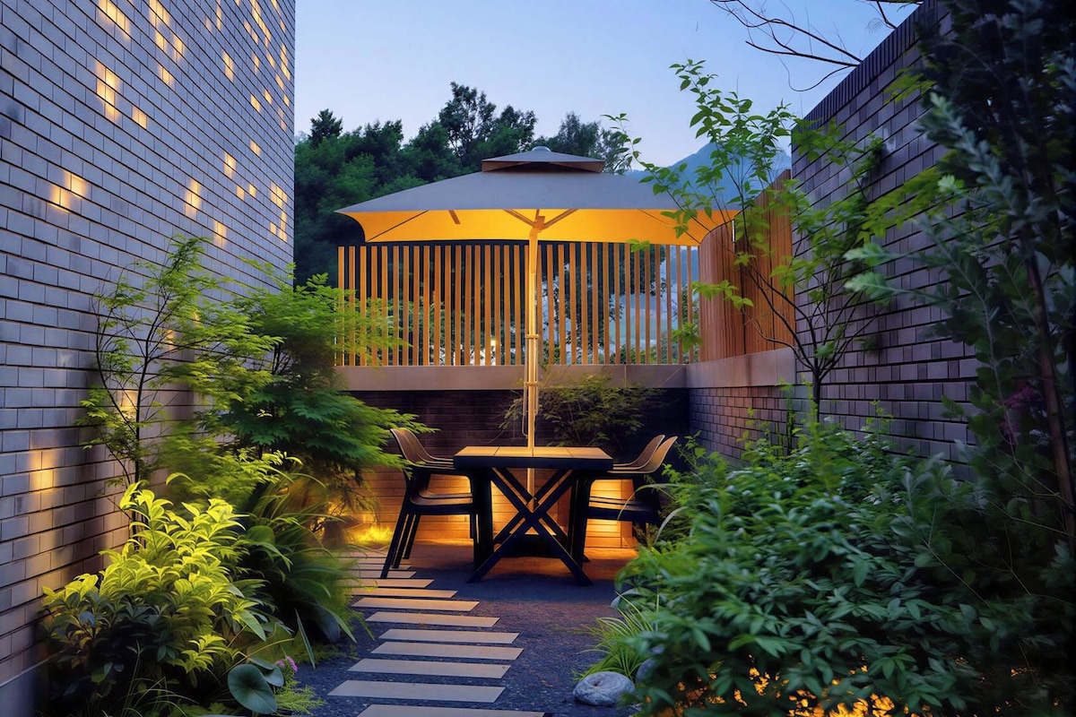 Une terrasse extérieure moderne, dotée d’un espace repas, d’un chemin en pierre et d’une végétation luxuriante.