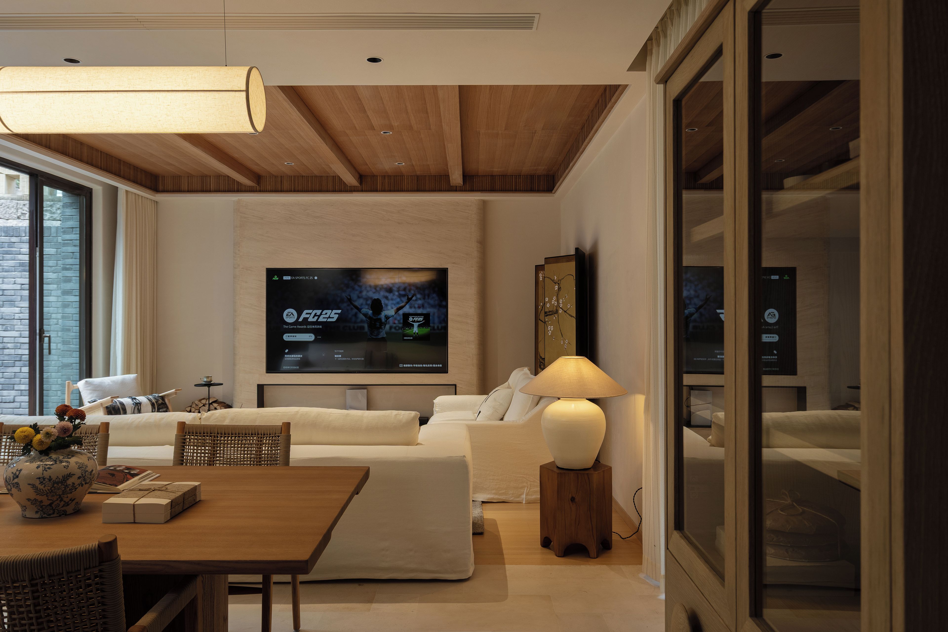 Una sala de estar moderna con una televisión de pantalla plana montada en la pared, un sofá, una mesa de centro y una lámpara.