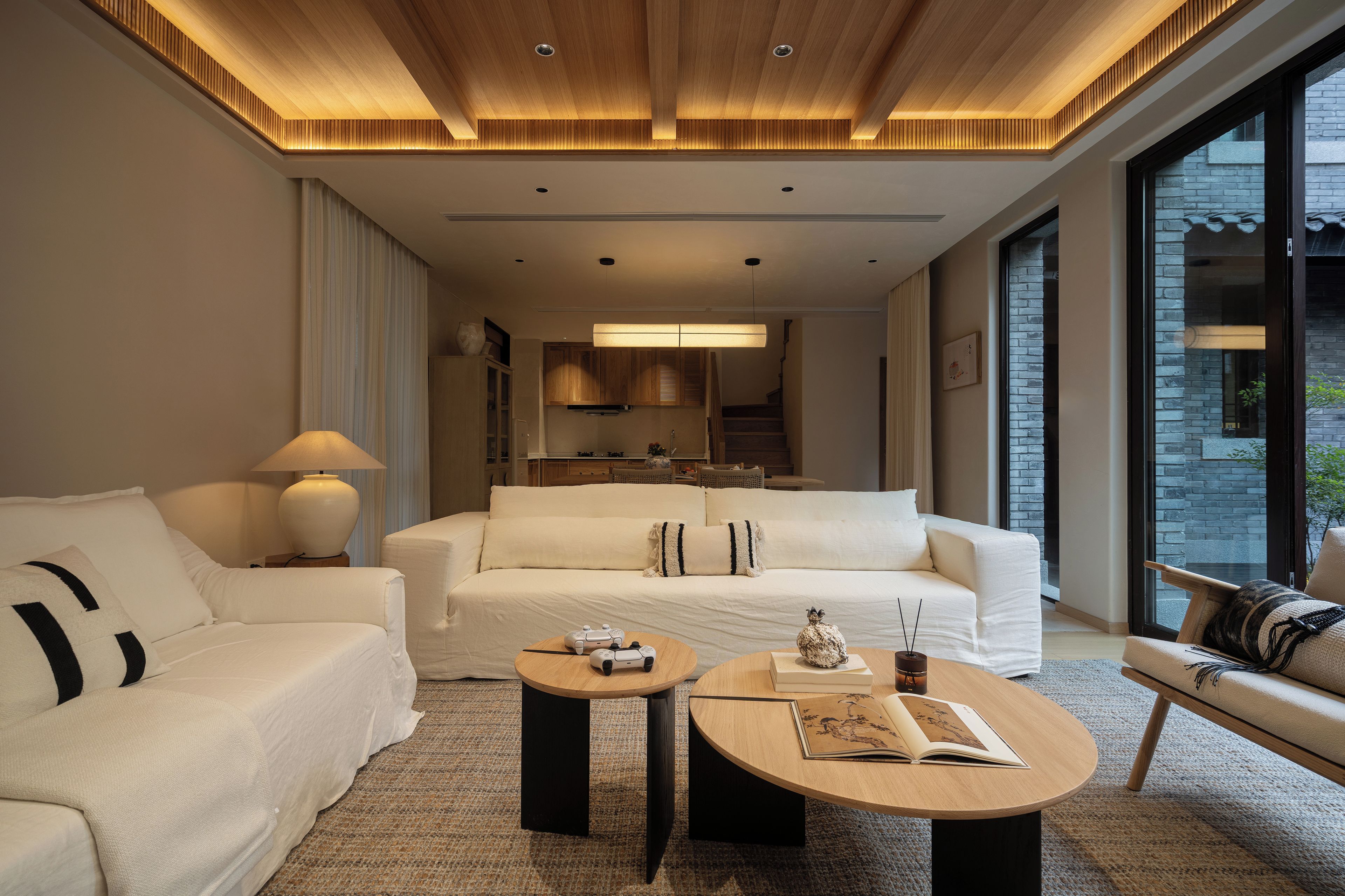 Habitación de hotel moderna con una cama grande, un sofá, una mesa de centro y vistas a la ciudad.