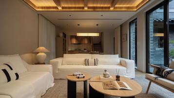 Habitación de hotel moderna con una cama grande, un sofá, una mesa de centro y vistas a la ciudad.