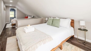 Una camera da letto con un letto grande, un comodino, una lampada e vista sul bagno.