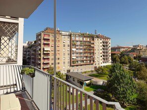A multi-story residential building with balconies, a gated entrance, and a clear view of the surrounding area. - The Washington Studio Apartment - Balcony (Milan)