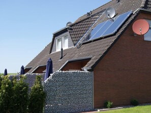 A house with a sloped roof, solar panels, and satellite dishes. - Holiday Home With 3 Bedrooms (Neuharlingersiel)