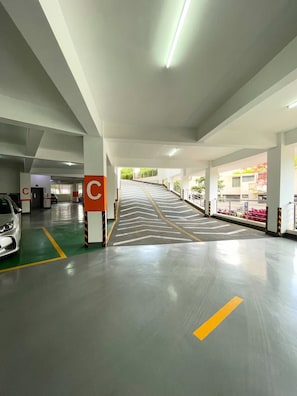Eine Parkgarage mit deutlichen Richtungshinweisen und einer zentralen Säule mit einem 'C'-Schild.