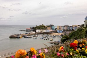 A coastal town with colorful buildings, a pier, and boats docked in the harbor. - 5 West -2 Bedroom House - Tenby (Tenby)