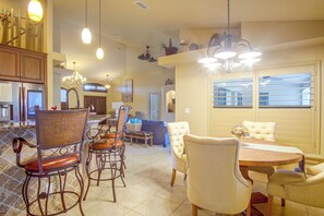 A spacious dining area with a high ceiling, multiple light fixtures, and a view of the city through large windows. - Private Yard w/ Fire Pit & Pool! Cape Coral Escape (Cape Coral)