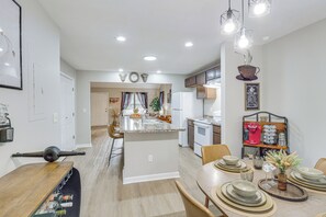 A modern kitchen with a central island, a dining area with a round table, and a coffee station. - Easy Access to 12 South! Nashville Home (Nashville)